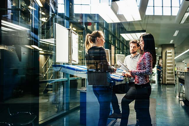 Two females and one male co-workers discussing a business plan