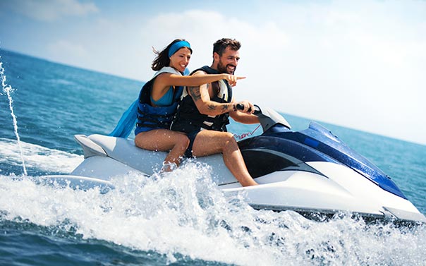 A young male riding a blue and white watercraft